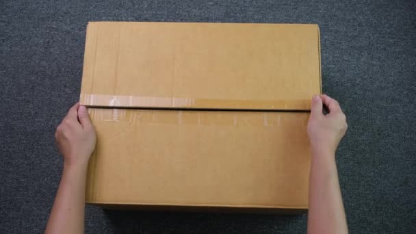 Detailní záběr rukou otevírajících kartónovou krabičku s výrobkem. Ruka zákaznice dostala dobrý balíček a vybalila krabici. Objednat poštovních poštovních kurýrní doručovací koncept. - Záběry, video