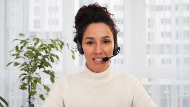 Confident Hispanic business woman wear wireless headset looking talking to webcam laptop, female professional company representative speak to camera conference calling by video chat at home office - Footage, Video