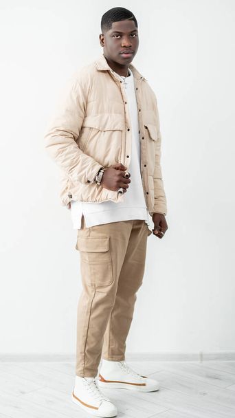Fashionable lifestyle. Confident man portrait. Trendy guy in beige outfit standing in studio - Fotoğraf, Görsel