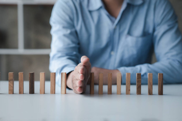 A close-up shot of a businessman holding the wooden blocks in a row, the wood blocks compare to the business risk management. The concept of risk management. copy space. - 写真・画像