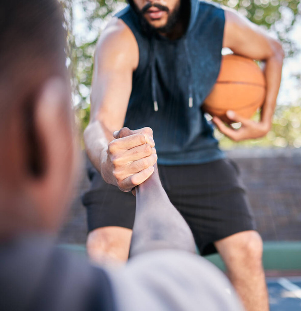 Mains, basket-ball et aide avec un athlète homme et rival jouant un jeu de compétition sur un terrain de sport. Equipe, exercice et assistance avec un joueur de basket aidant un ami lors d'un match à l'extérieur. - Photo, image