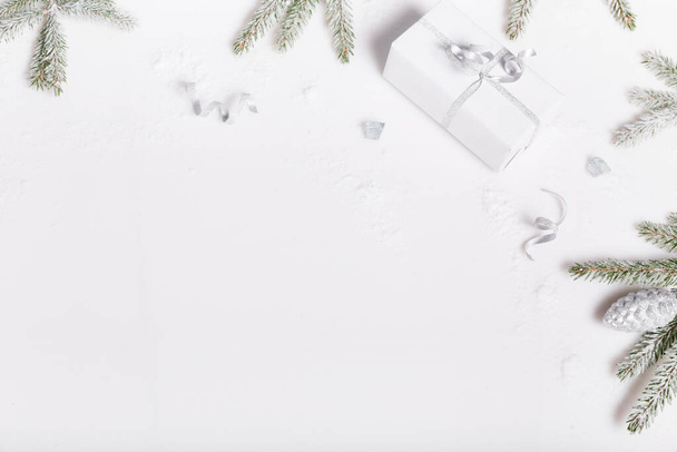 Cajas de regalo de Navidad y ramas de abeto cubiertas de nieve sobre un fondo blanco, vista superior, puesta plana. Feliz Navidad tarjeta de felicitación, marco. Feliz Año Nuevo. - Foto, imagen