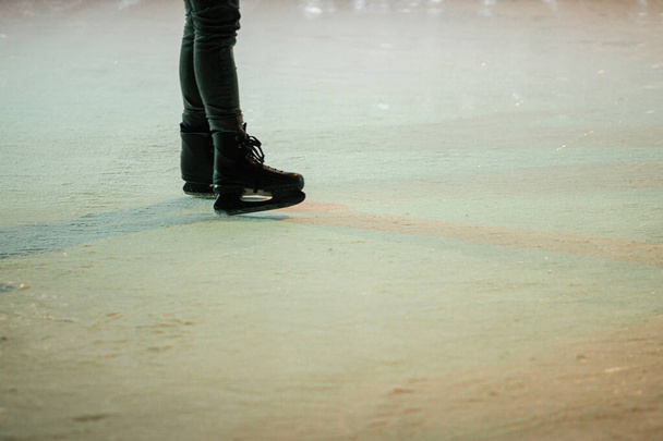 Patinadores de gelo no ringue de gelo, patins de perto. Pessoas se divertindo e patinando na praça da cidade à noite.Pernas com patinadores de gelo vista cortada. Férias atmosféricas de Inverno na Europa. Boas festas.! - Foto, Imagem