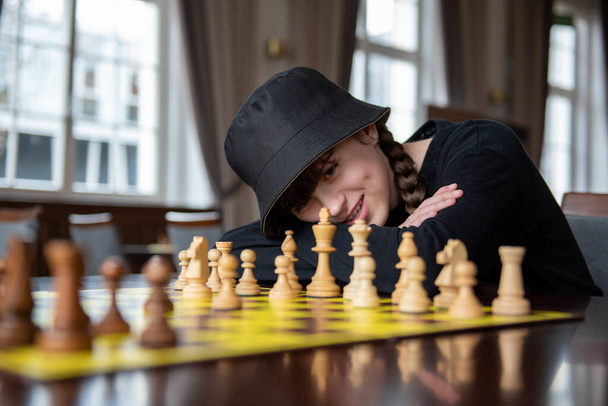 A rapariga joga xadrez. Peças no tabuleiro de xadrez. Jogo de xadrez, close-up, retrato. Torneio de xadrez, competição - Foto, Imagem