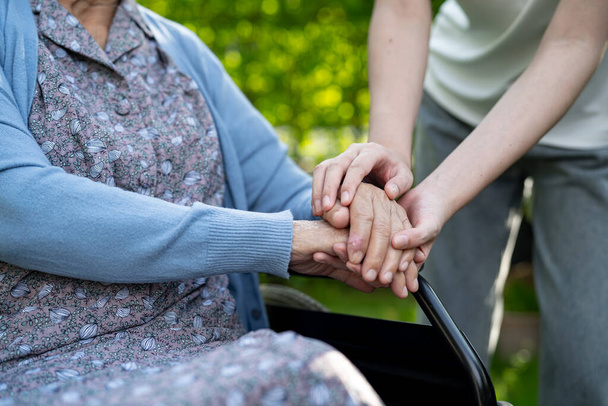 Aide soignant tenant la main femme âgée asiatique patient, aide et voiture à l'hôpital. - Photo, image