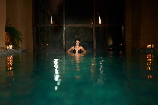 Mineral bliss. Portrait of a young woman relaxing in a spa swimming pool - Fotografie, Obrázek