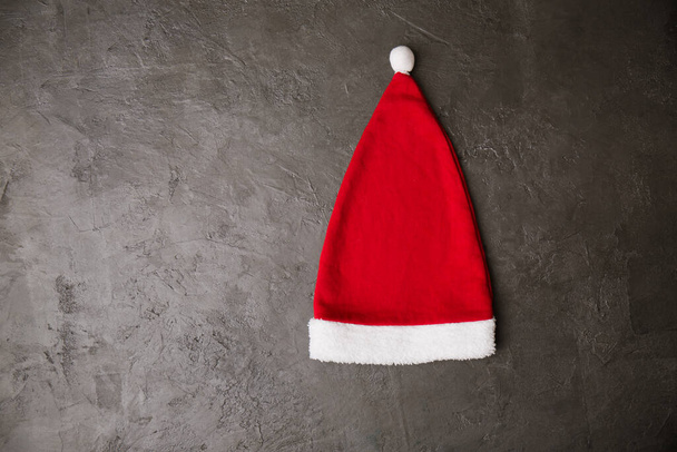 Vörös Mikulás kalap szürke háttérrel. Karácsonyi koncepció - Fotó, kép