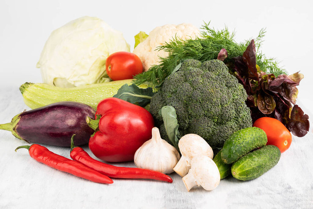Peppers, cucumbers, eggplant, zucchini, various cabbages, dill, mushrooms and lettuce on a white background. Healthy food concept. - Photo, image