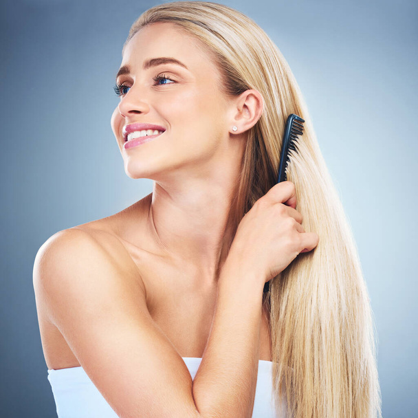 Woman comb hairstyle, beauty and self care, grooming and cosmetics routine on studio background for smooth, shine and clean texture. Happy model brush blond hair care, scalp and head after shower. - Photo, Image