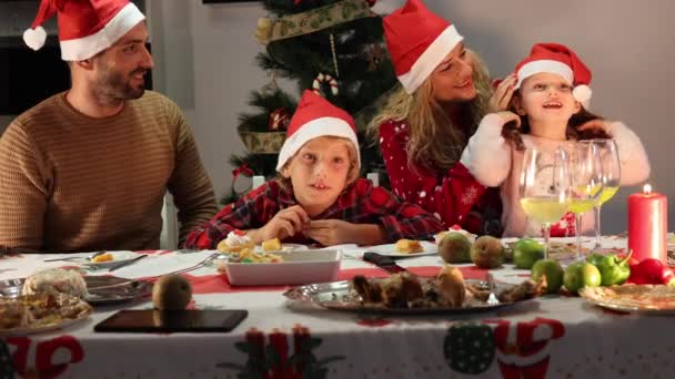 mooie Kaukasische familie vieren kerst thuis na het eten. - Video