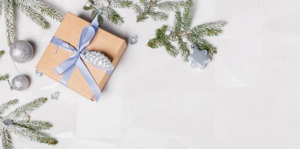 Рождественские подарочные коробки и елки, покрытые снегом на мраморном фоне, вид сверху, плоский уголок. С рождественской открыткой в рамке. С Новым годом. - Фото, изображение