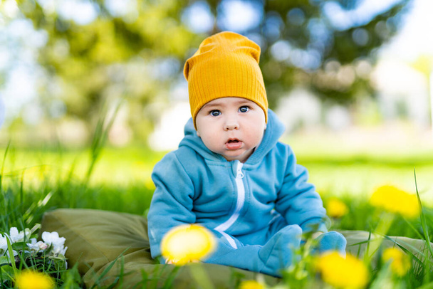 Cute pretty newborn sitting on the garden. Portrait of young little boy in nature. - Foto, afbeelding