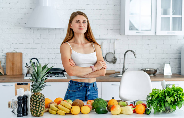 Young pretty lady with healthy organic food. Vegetarian food cooking. - Foto, afbeelding