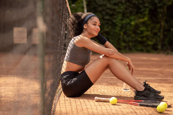 Tenista. Pěkná mladá tmavovlasá dívka odpočívající po hře - Fotografie, Obrázek