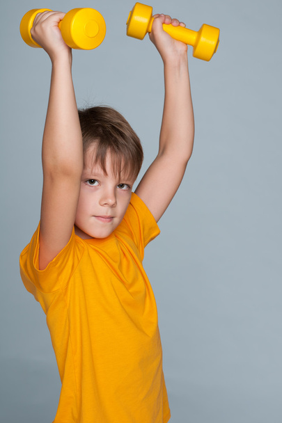 Cute young boy with dumbbells - Photo, Image
