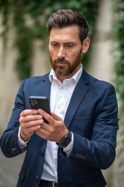 Phone call. Elegant young businessman with a phone in hands - Foto, Imagen
