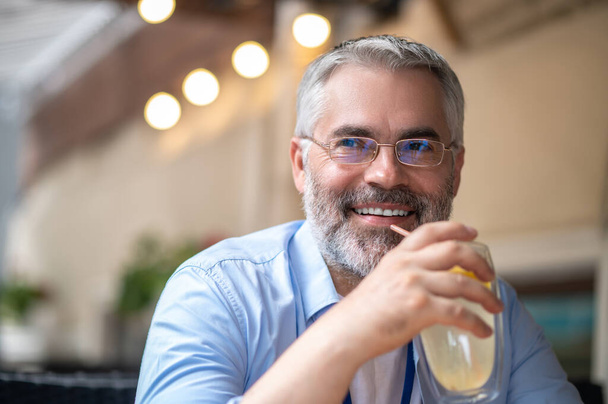 Happy man. Smiling man with a glass in hands looking happy - Foto, imagen