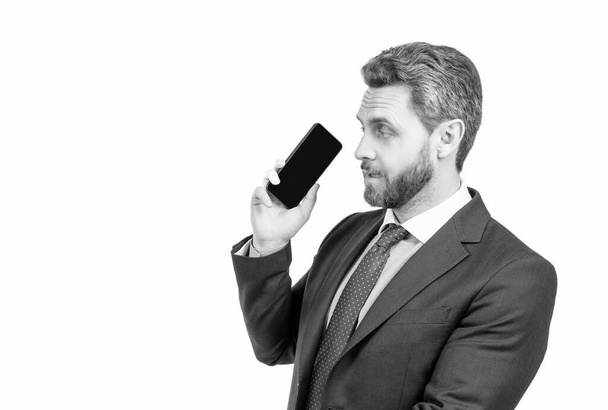 Серйозний професійний менеджер в офіційному костюмі тримає мобільний телефон ізольований на білому копіювальному просторі, смартфон
. - Фото, зображення