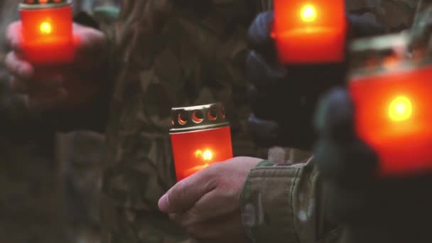 Az emlékezés napja, nehogy elfelejtsük. Emléknap gyertyákkal. Meggyújtották az emlékgyertyákat. Ukrán katonák katonai egyenruhában, vörös gyertyákkal a kezükben. Katonák a katonai felvonuláson. - Felvétel, videó