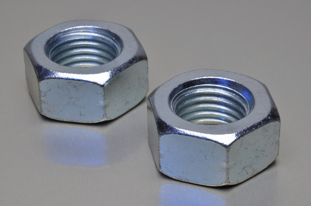 Two steel nuts with blue light reflection - Photo, Image
