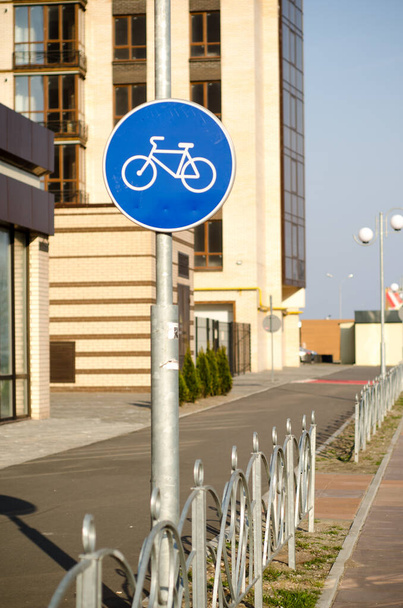 Segnaletica stradale blu Pista ciclabile con recinzione in metallo, in città vicino a un edificio alto - Foto, immagini