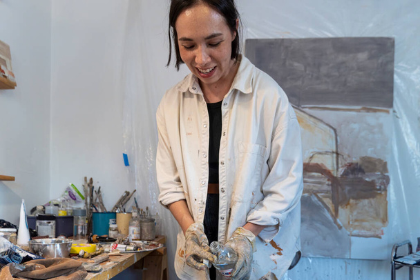 Młoda Latynoska kobieta, we własnym pracowni malarstwa i rzeźby, tworzy obrazy z różnymi technikami artystycznymi mexico latin america - Zdjęcie, obraz