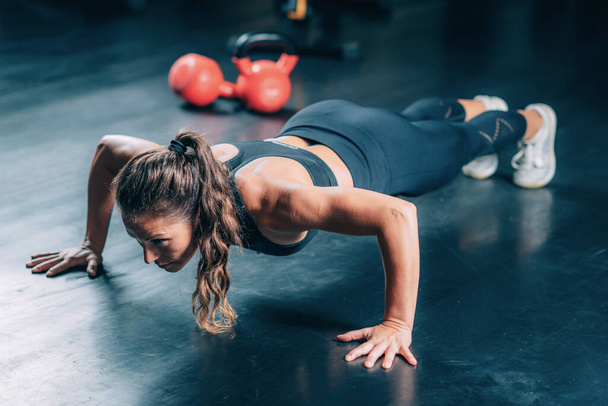 Woman Doing Push-ups in the gym. Strength Training. - Фото, зображення
