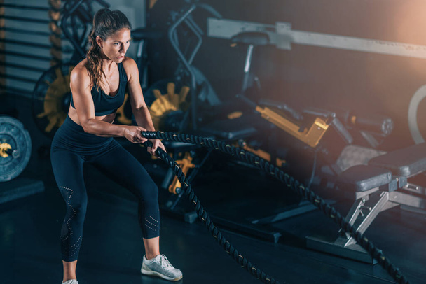Treinamento de agilidade, mulher se exercitando com corda em um ginásio.  - Foto, Imagem