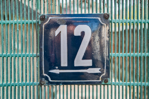 Plaque émaillée de métal carré grunge altérée du nombre d'adresse municipale avec le numéro 12 - Photo, image