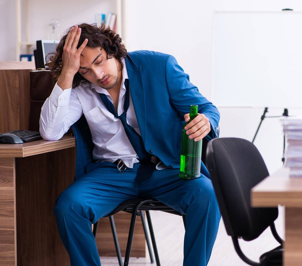 El joven empleado borracho en la oficina - Foto, imagen