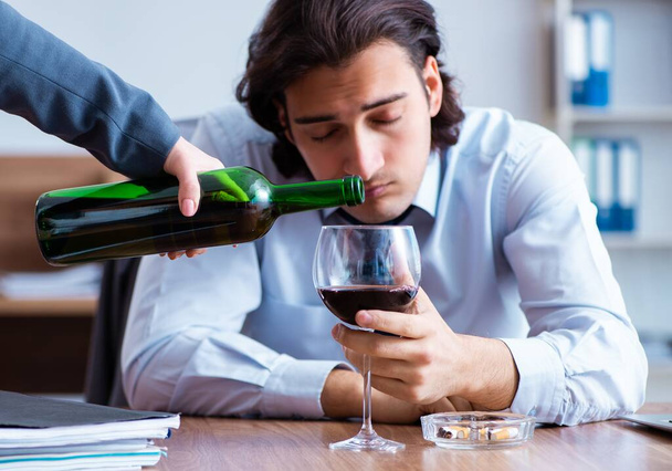 A férfi alkalmazott alkoholt iszik és cigarettázik a munkahelyen - Fotó, kép