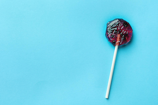 Sweet colorful lollipop with berries on light blue background, top view. Space for text - Фото, зображення