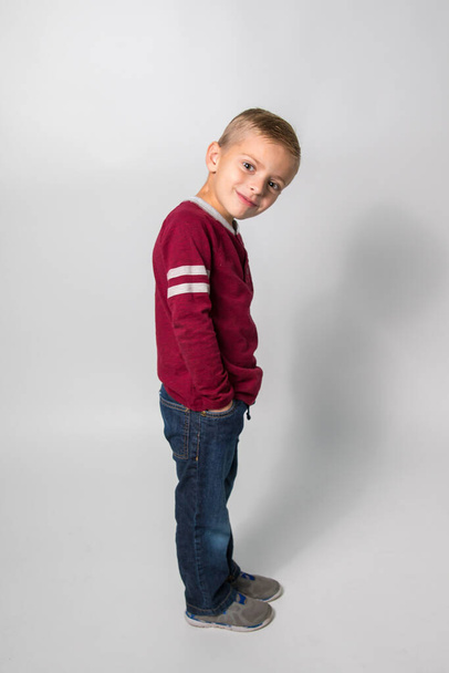 A little boy standing on a white background and looking at the camera - Photo, Image