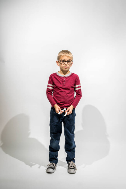 Little Boy With Big Glasses Standing Looking at Camera Against a White Background - Фото, изображение