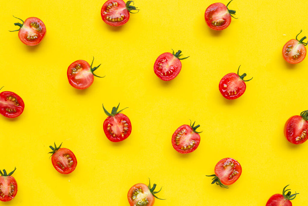 Fresh tomatoes, whole and half cut isolated on yellow background. Top view - Foto, Imagen