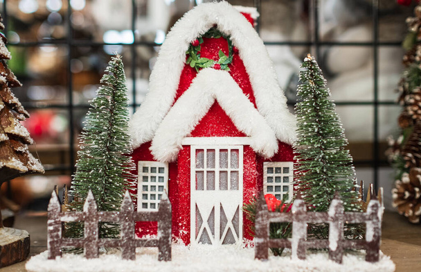 Мініатюрний дерев'яний будинок з ялинками та снігом. Різдвяні або новорічні прикраси фону. Концепція затишного будинку взимку. Інтер'єр вітальні та домашній декор. Ніхто, розмитий
 - Фото, зображення