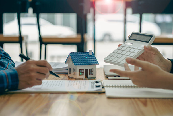 Agenti immobiliari raccomandano case e offrono contratti di tasso di interesse di assicurazione ai clienti nell'ufficio idea di acquisto casa. - Foto, immagini