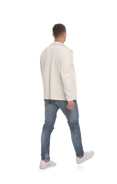 Man in casual outfit walking on white background, back view - 写真・画像