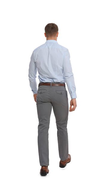 Man in formal outfit walking on white background, back view - Photo, Image