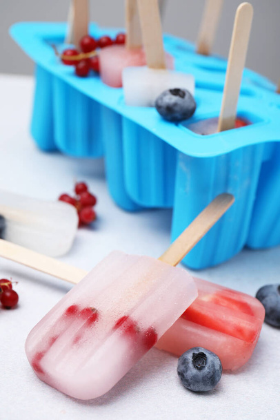Tasty berry ice pops on light table, closeup - 写真・画像