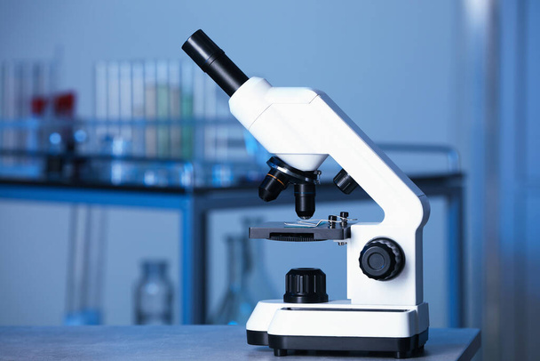 Modern medical microscope on gray table in laboratory, space for text - Photo, image