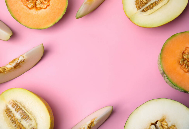 Tasty colorful ripe melons on pink background, flat lay. Space for text - 写真・画像