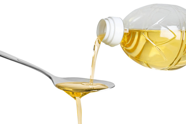 Pouring cooking oil from bottle into spoon on white background, closeup - Foto, Bild