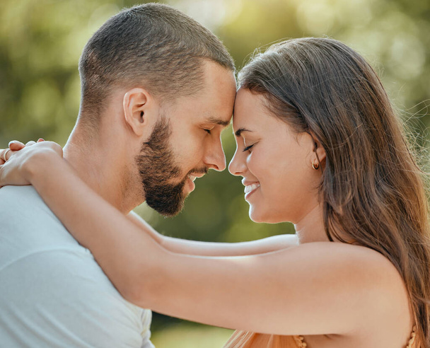 Couple, love and forehead touch in garden, summer park or outdoor backyard in Spain for care, happiness and easy lifestyle together. Smile, romance and date of man, woman and people in happy marriage. - 写真・画像
