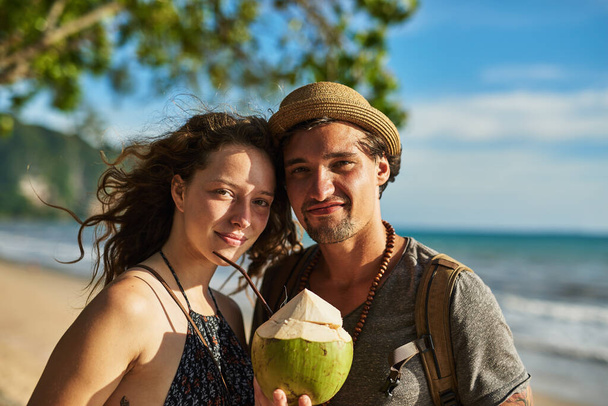 Verão tal como nós gostamos. Retrato de um jovem casal feliz desfrutando de coquetéis enquanto relaxa na praia - Foto, Imagem