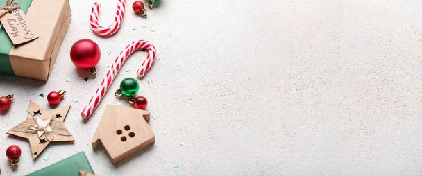 Słodkie laski cukierki, dekoracje świąteczne i prezent na lekkim tle z miejsca na tekst - Zdjęcie, obraz