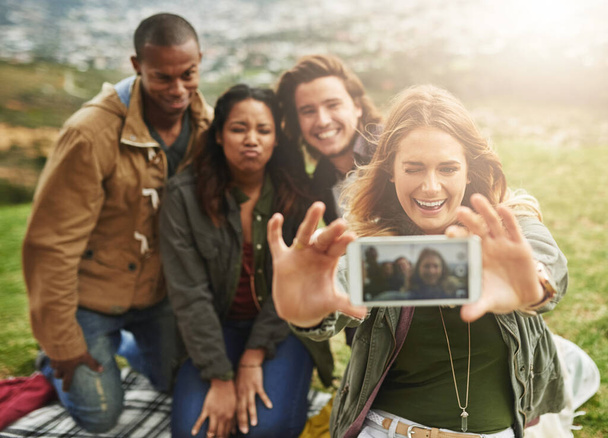 Trova amici che siano il tuo genere di pazzi. un gruppo di amici che si fanno un selfie in piedi fuori - Foto, immagini