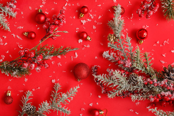 Fir branches with rowan, Christmas balls and snow on red background - Φωτογραφία, εικόνα