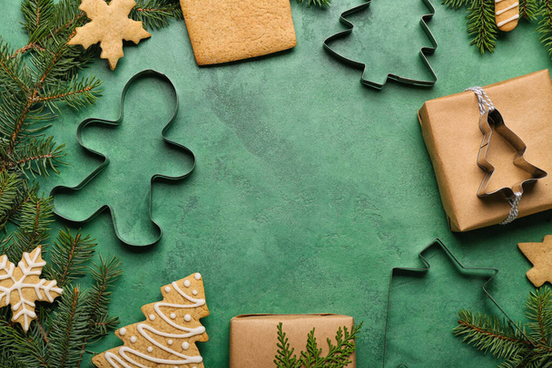 Quadro feito de saborosos biscoitos de Natal, cortadores e ramos de abeto no fundo de cor, close-up - Foto, Imagem