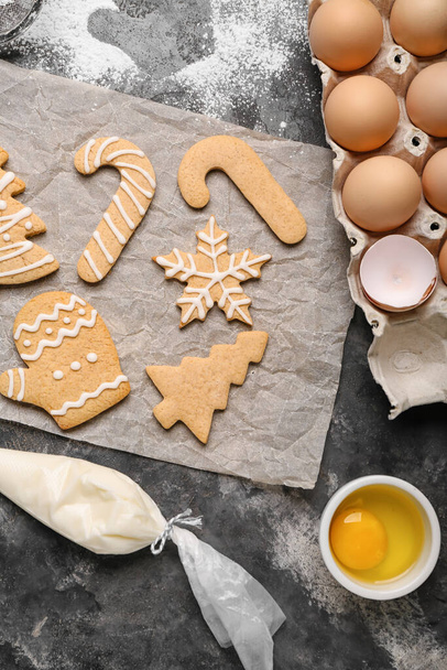 Φύλλο λαδόκολλα με νόστιμα χριστουγεννιάτικα μπισκότα, αυγά και κρέμα γάλακτος σε φόντο grunge - Φωτογραφία, εικόνα